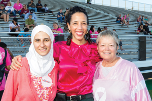 From left, MD Anderson physicians Sausan Abouharb and Valerie Reed joined with Ann Hammond, Clear Creek ISD board president and breast cancer survivor, to address the crowd with a message about breast cancer awareness during Clear Creek High School’s football game against Brazoswood on Oct. 9. 